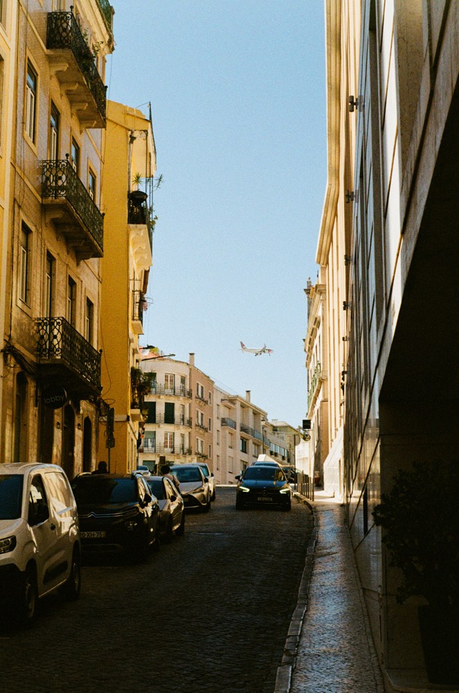 Airplane between sunlit buildings on a narrow street