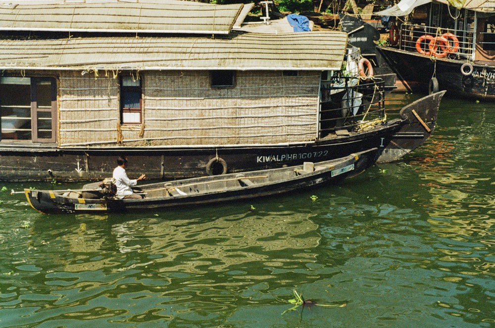 A canoe passing a moored houseboat