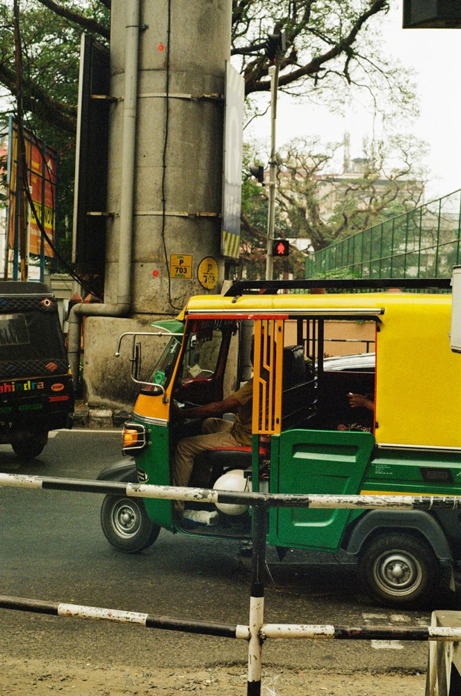 Yellow and green auto rickshaw on a city street