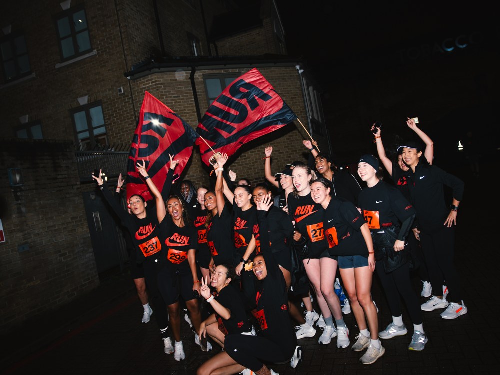 Runners celebrating with red Nike Run flags