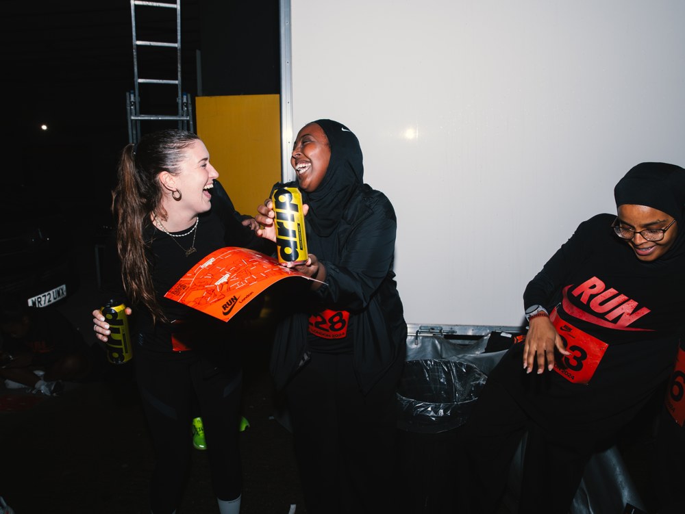 Runners laughing together with Drip Water cans