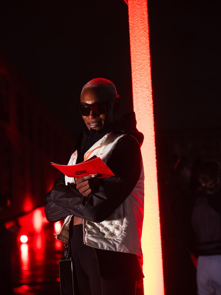 Event guest holding a Nike Run card beside a red light