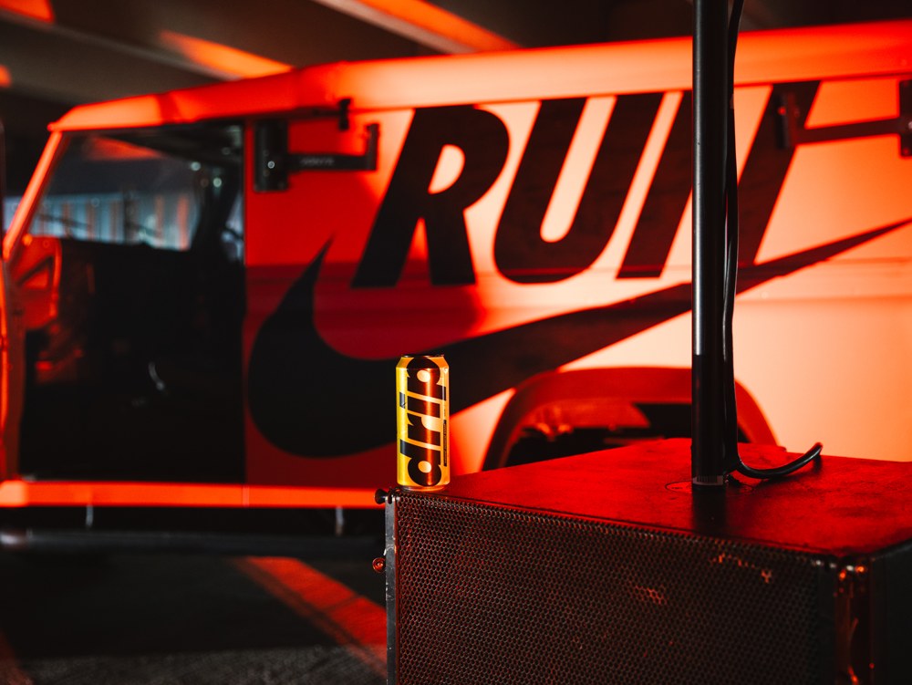 Drip Water can in front of a Nike Run vehicle