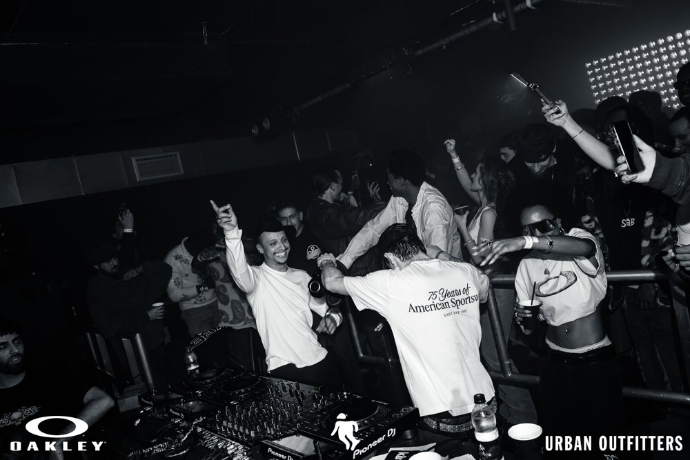 Guests dancing beside the DJs at the Oakley and Urban Outfitters event