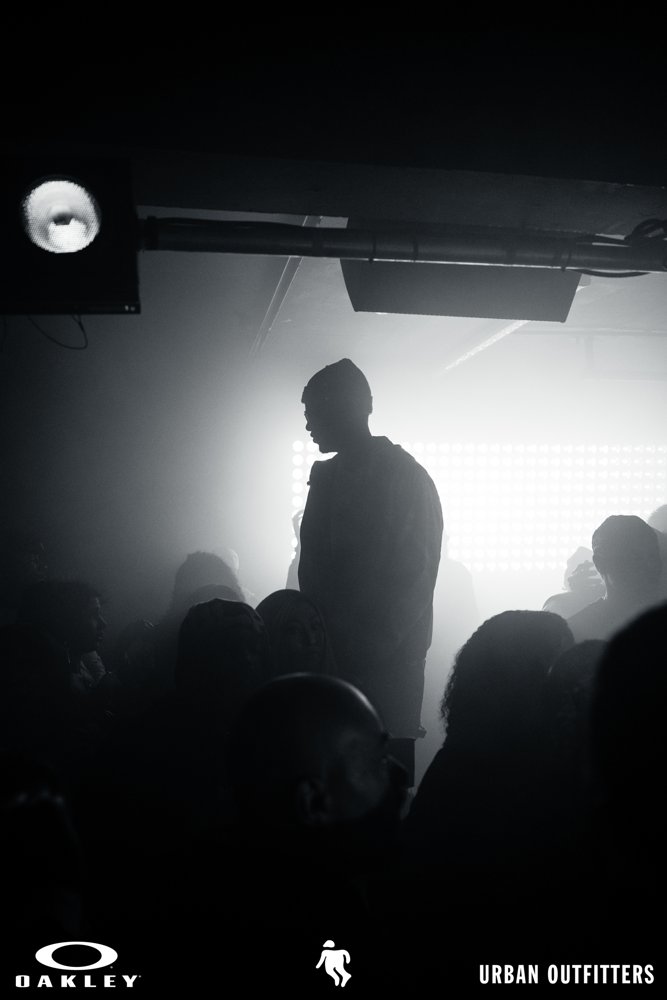 Performer silhouetted against stage lights at the Oakley and Urban Outfitters event