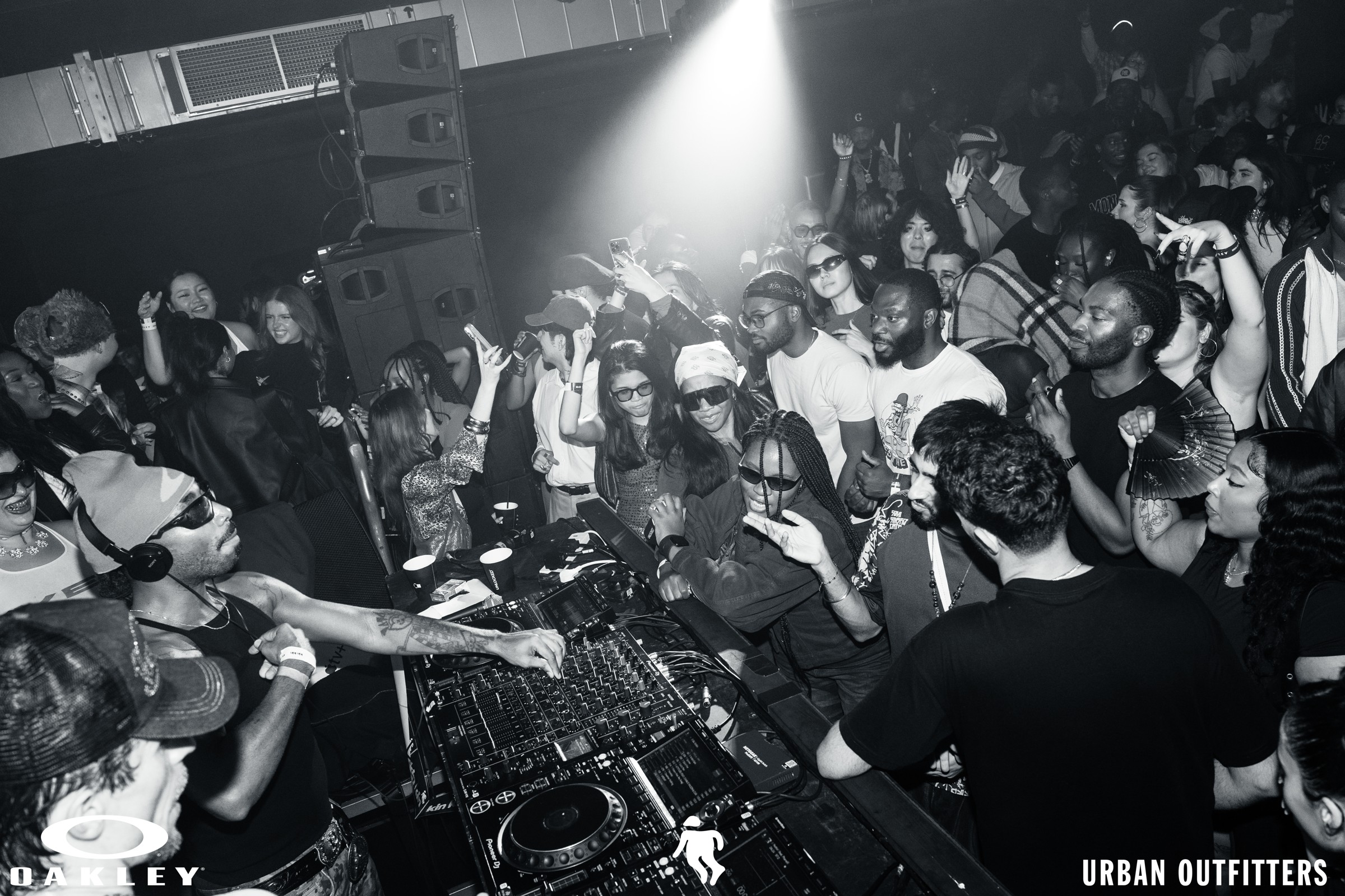 DJs surrounded by a lively crowd at the Oakley and Urban Outfitters event