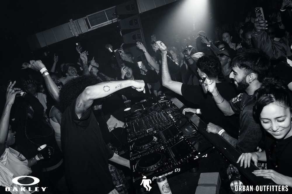DJ and guests raising their hands at the Oakley and Urban Outfitters event